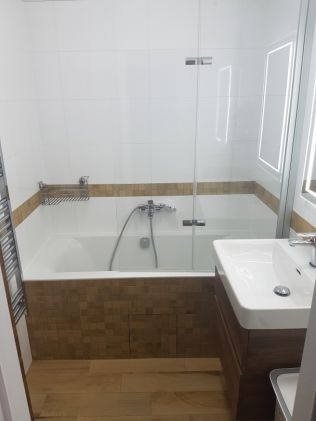 Tip: dřevo v kombinaci s bílým obkladem může vytvořit uklidňující atmosféru